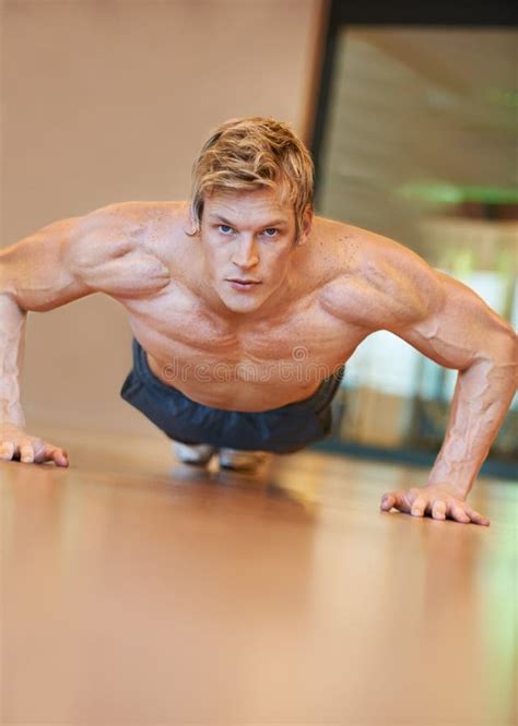 Showing Off His Upper Body Strength. Fit Young Man Doing Push Ups in a Health Club. Stock Photo ...