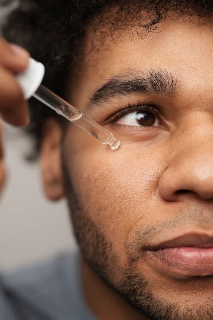Free Photo | Close up man applying face serum