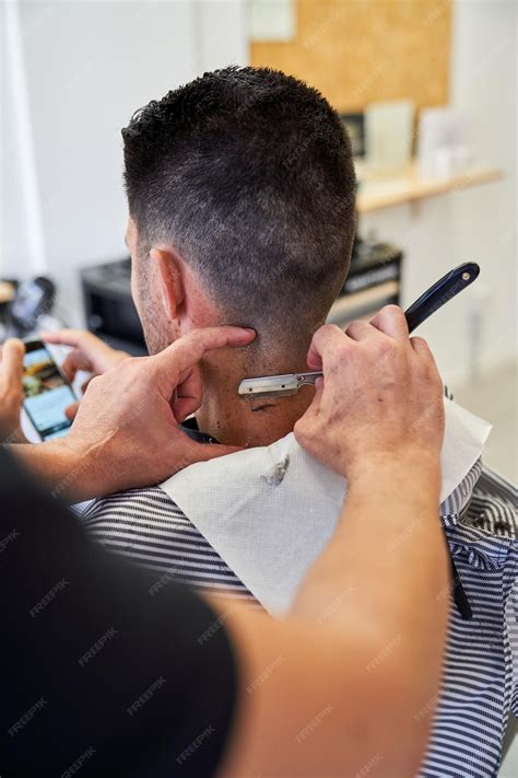Premium Photo | Unrecognizable barber shaving neck of man in salon