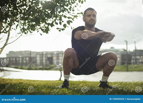 Young Attractive Man Squatting Outdoor in the Park with Outstretched ...