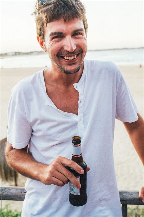 «Young Man Laughing With A Bottle Of Beer In His Hand On A Beach At ...