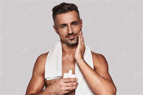 Premium Photo | Confident in his skin. handsome young man applying ...