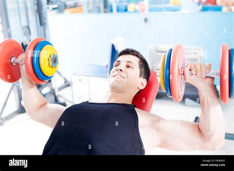 Young handsome man lifting heavy free weights at the gym Stock Photo ...