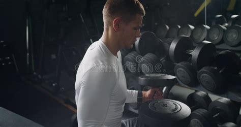 Focused Young Man Lifting Weights in a Modern Gym Setting Stock Footage ...