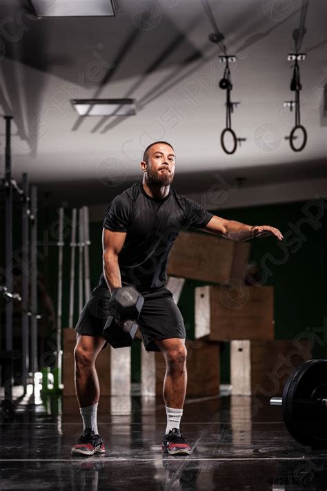 Muscular athlete lifting very heavy weights Man working out indoors ...