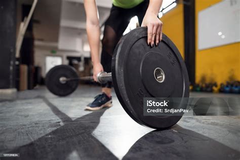 Unrecognizable Female Athlete Adding Weights On The Barbell In The Gym ...