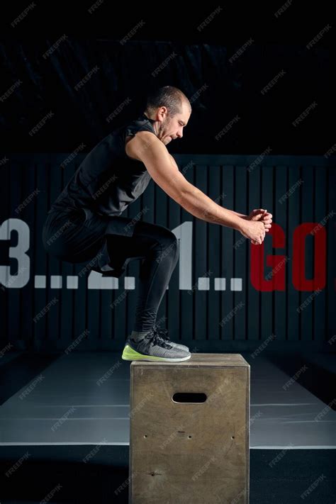 Premium Photo | Fit young man jumping onto a box as part of exercise ...