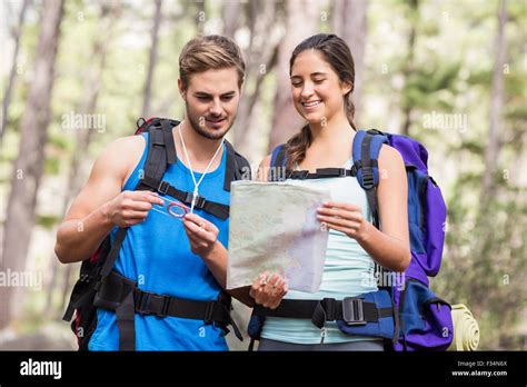 Happy hikers looking at map Stock Photo - Alamy