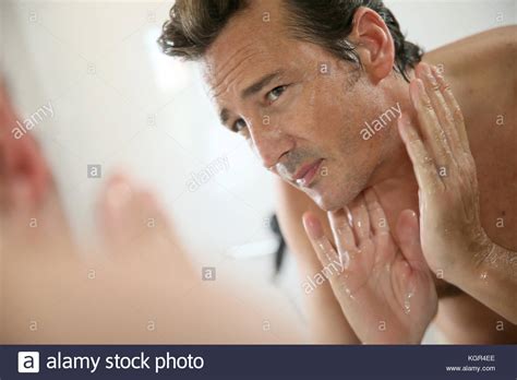 Handsome man rinsing face after shaving Stock Photo - Alamy