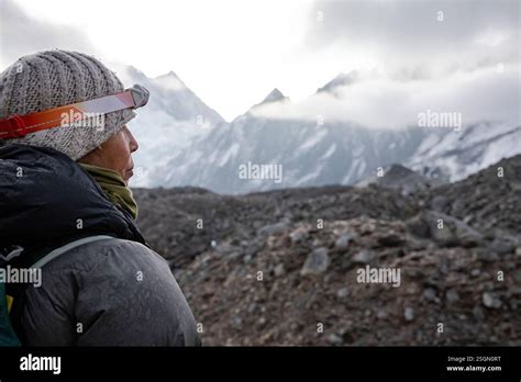 Female wears cold weather gear and headlamp while trekking Nepal Stock Photo - Alamy
