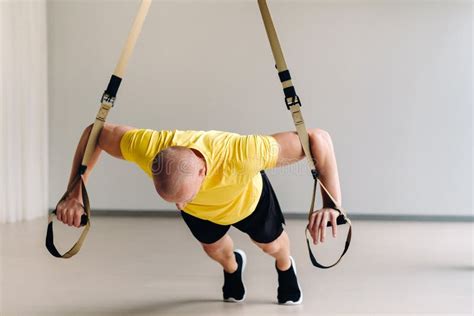 A Focused Male Athlete Performing an Exercise on Functional Loops in ...