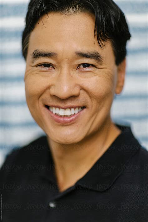 «Portrait Of Handsome Happy Asian Man With Smile» del colaborador de Stocksy «Raymond Forbes LLC ...