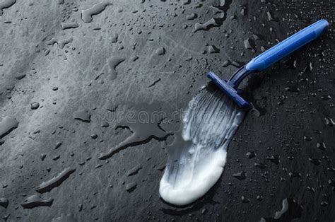 Blue Sharp Razor and Smear of Shaving Cream on the Wet Dark Surface.Empty Space for Text Stock ...
