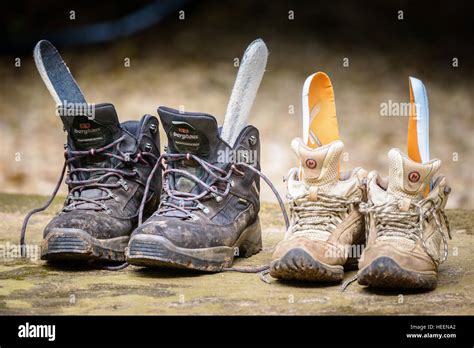 Two sodden soaking wet saturated pairs of walking boots drying out. His ...