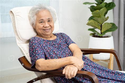 Asian elderly woman sitting and relaxing with happy in rocking chair at room in home. 13882799 ...
