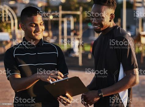 Shot Of A Young Man Planning His Workout Routine With His Personal ...