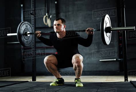 Active man lifting weight during workout in gym - Royalty-free Stock ...