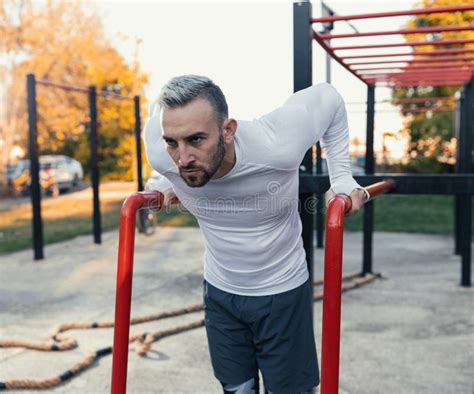 Handsome Man Doing Dips on Parallel Bars Boosting His Chest Muscles Stock Photo - Image of ...