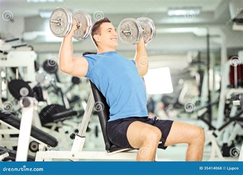 Smiling Muscular Guy Lifting Weights in Gym Club Stock Photo - Image of ...