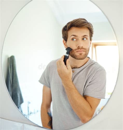 One Handsome Man Shaving His Face Hair in a Bathroom at Home. Caucasian ...