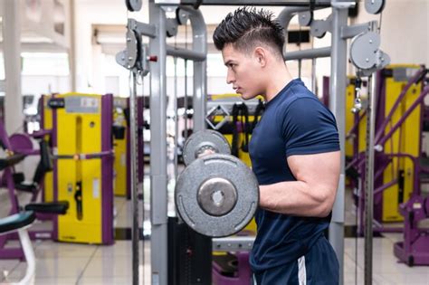 Premium Photo | Man in gym lifting weights with strong training