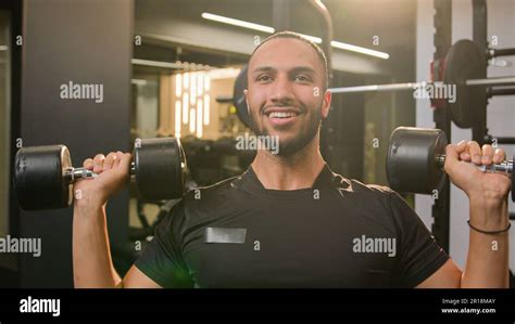 Happy smiling African American sportsman doing power exercise at gym ...