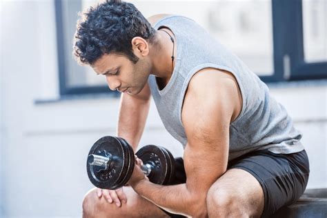 Premium Photo | Handsome young man workout with dumbbell at gym