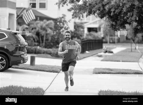 energetic running man races down neighbourhood. running man enjoys the ...