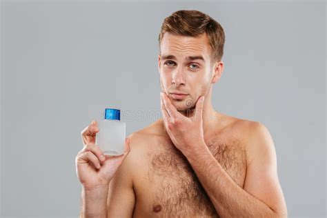 Handsome young man applying lotion after shave on face - Stock Image - Everypixel