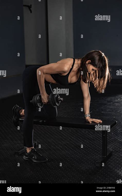 Focused Fitness A Woman Engaging in Strength Training with a Dumbbell ...