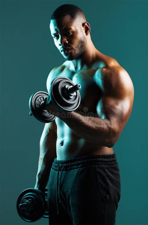 Lift it Like You Mean it. a Handsome Young Man Lifting Weights Against ...