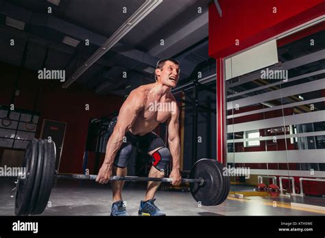 Young man lifting barbells during deadlift workout Stock Photo - Alamy