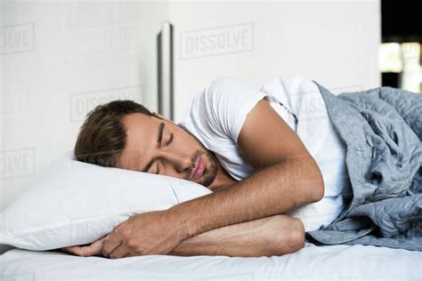 Attractive young man sleeping peacefully in bed - Royalty-free Stock ...