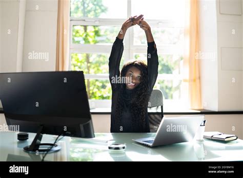 African Woman Stretching Exercise At Desk Working On Computer Stock Photo - Alamy