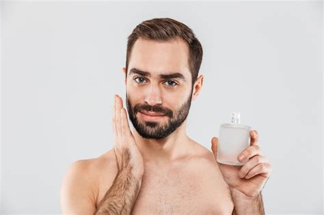 Premium Photo | Portrait of a cheerful shirtless bearded man applying aftershave lotion isolated ...