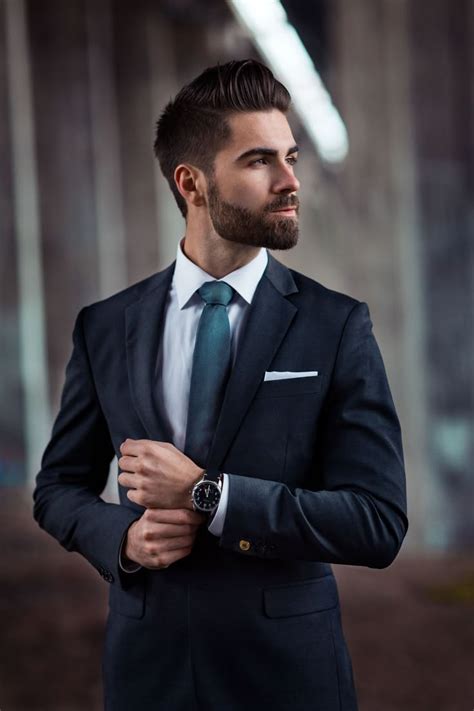 a man in a suit and tie standing with his arms crossed